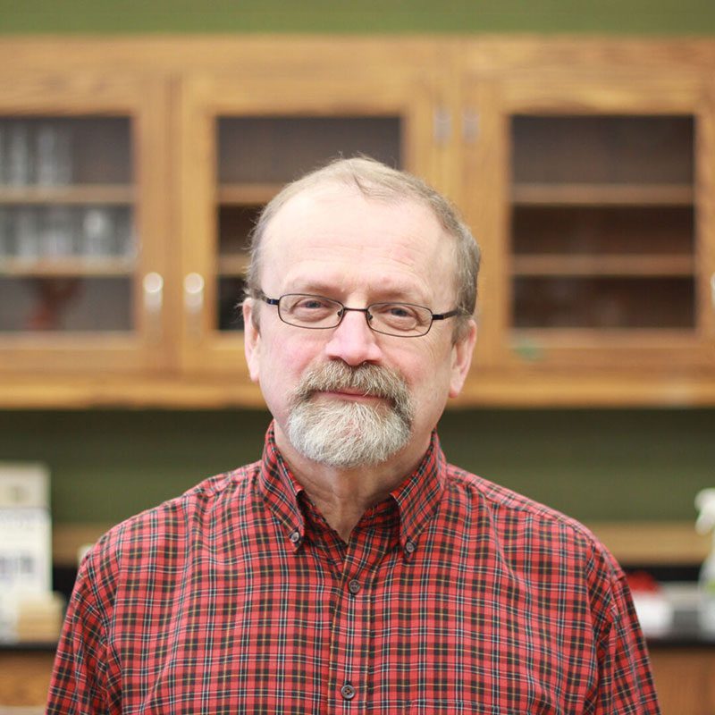 Houghton professor Don Wilcox standing in lab.