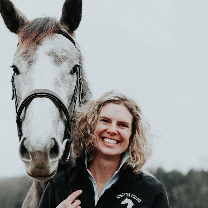 Houghton faculty member Andrea Boon standing with horse.