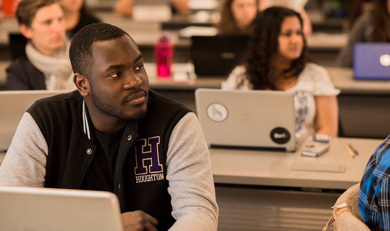 Houghton accounting student wearing Houghton jacket in business class.