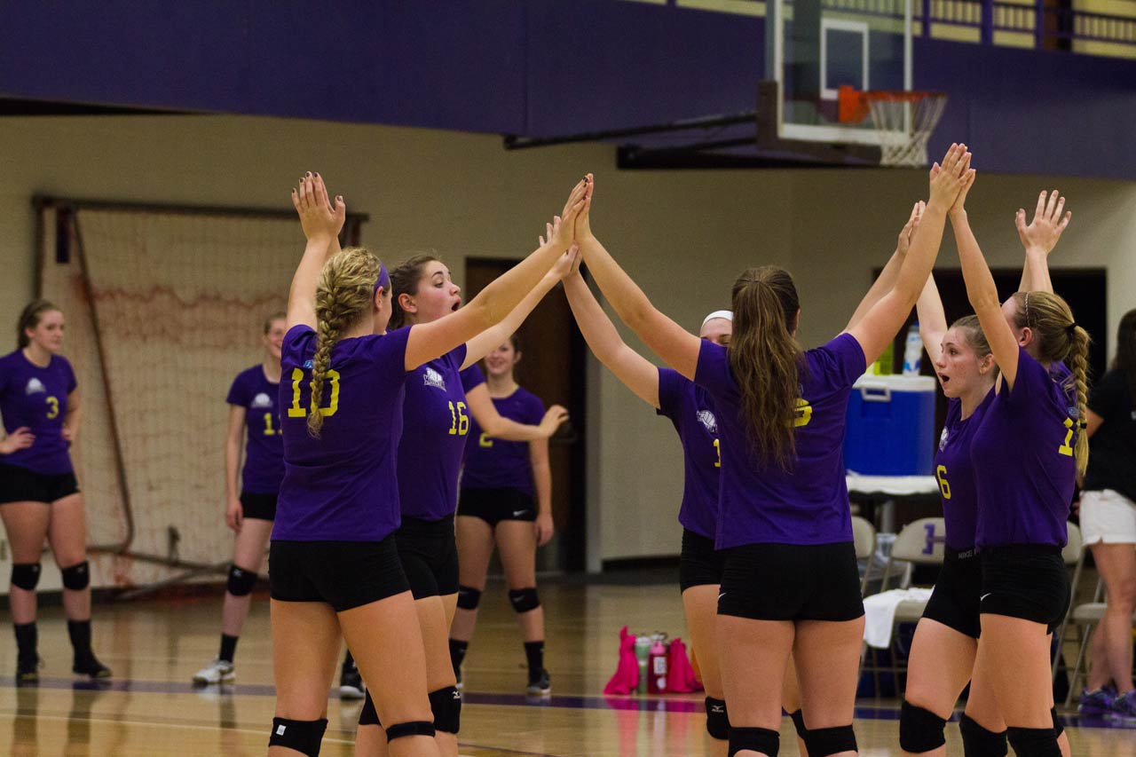 Women's volleyball team in huddle