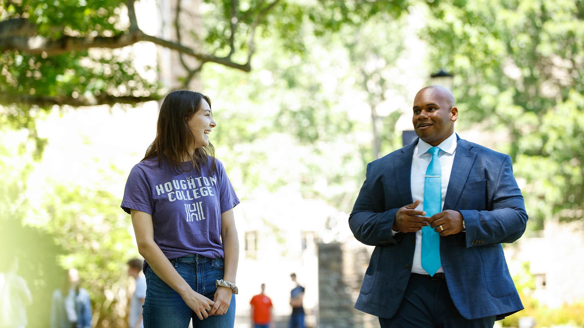 President Lewis walking with a student on the Quad