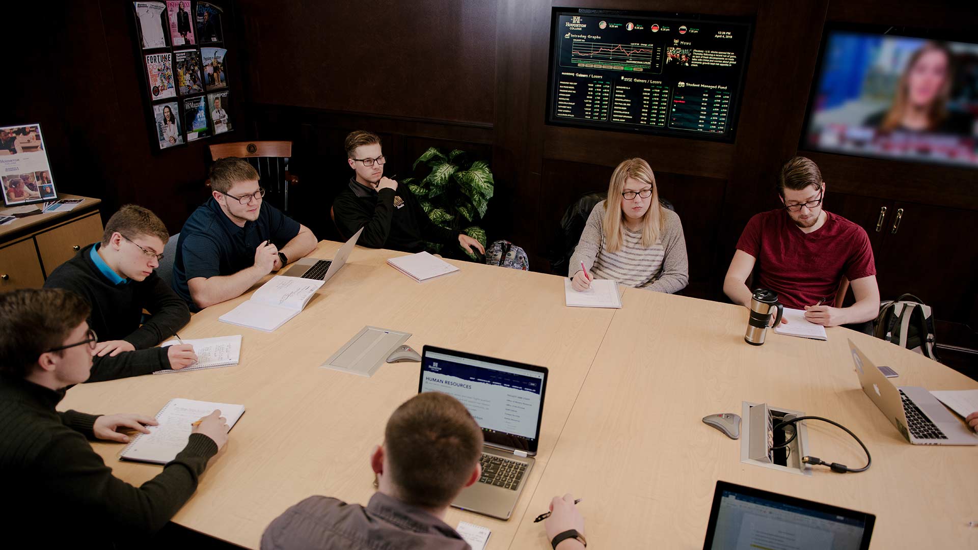 students sitting at conference table in the student investment center