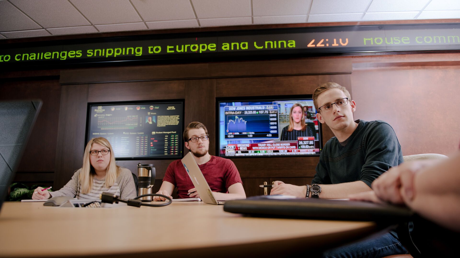 Students sitting at conference table in investment center