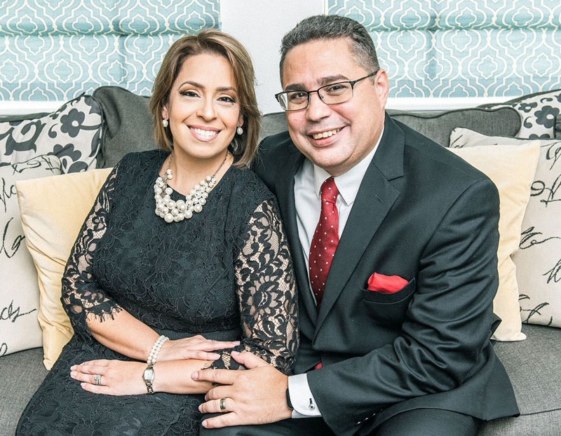 Rev. Dr. Gabriel Salguero posing with his wife while sitting on a couch