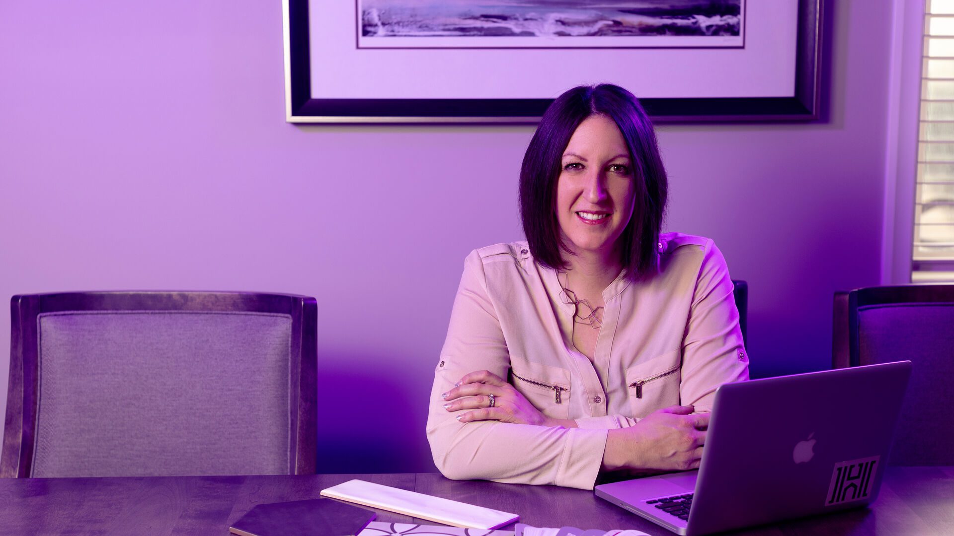 Alumna of Houghton's Christian MBA program, Sandra Hussin, sitting at table with laptop.