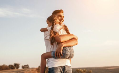 Father holding his daughter in a bear hug