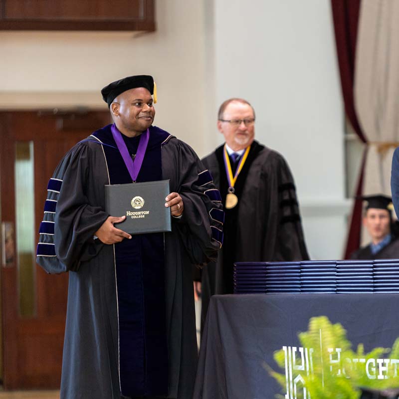 President Lewis and Board of Trustee Chair, John Lee, standing with diplomas at commencement