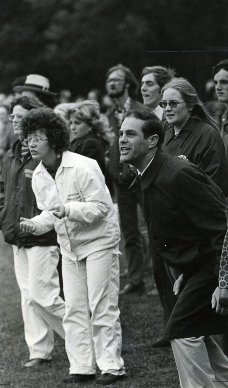 President Emeritus Chamberlain cheering at a sports event from the sidelines.
