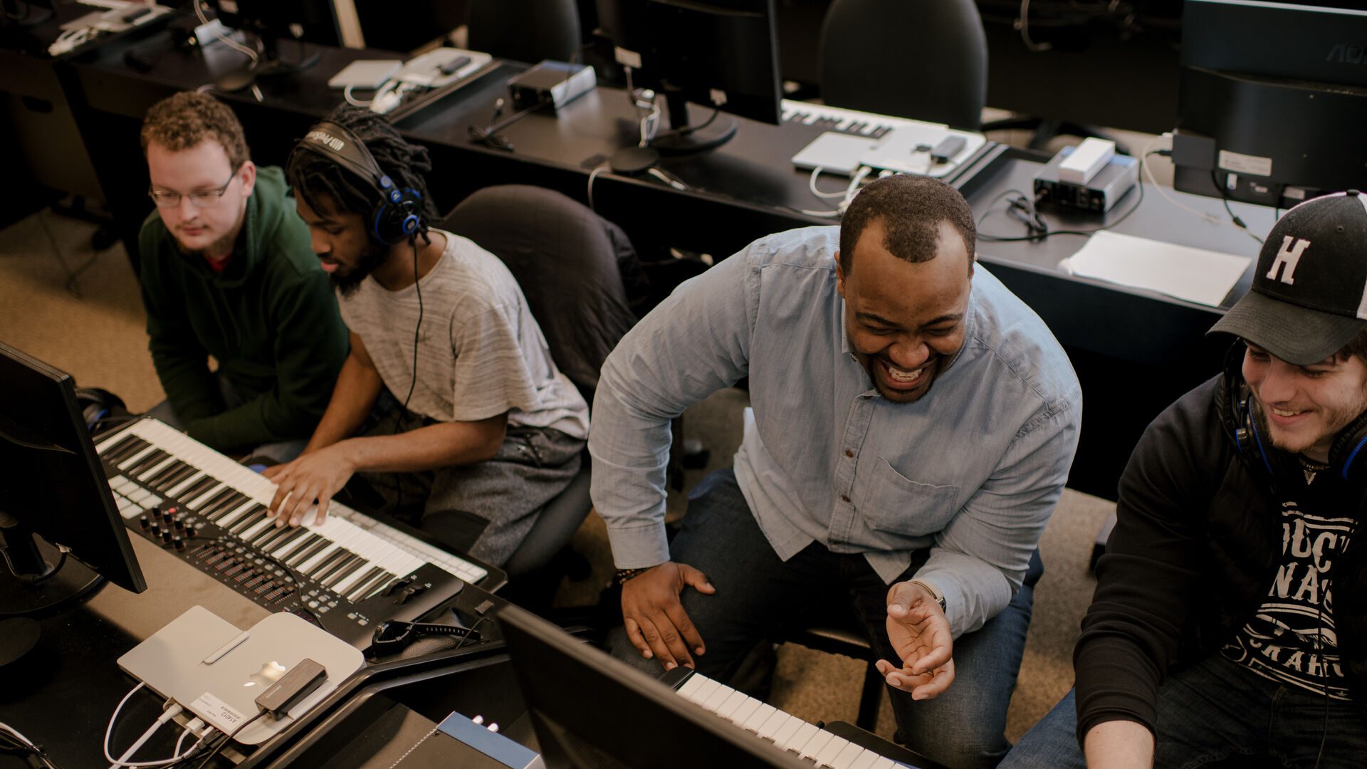 Houghton professor working with student in music industry lab.