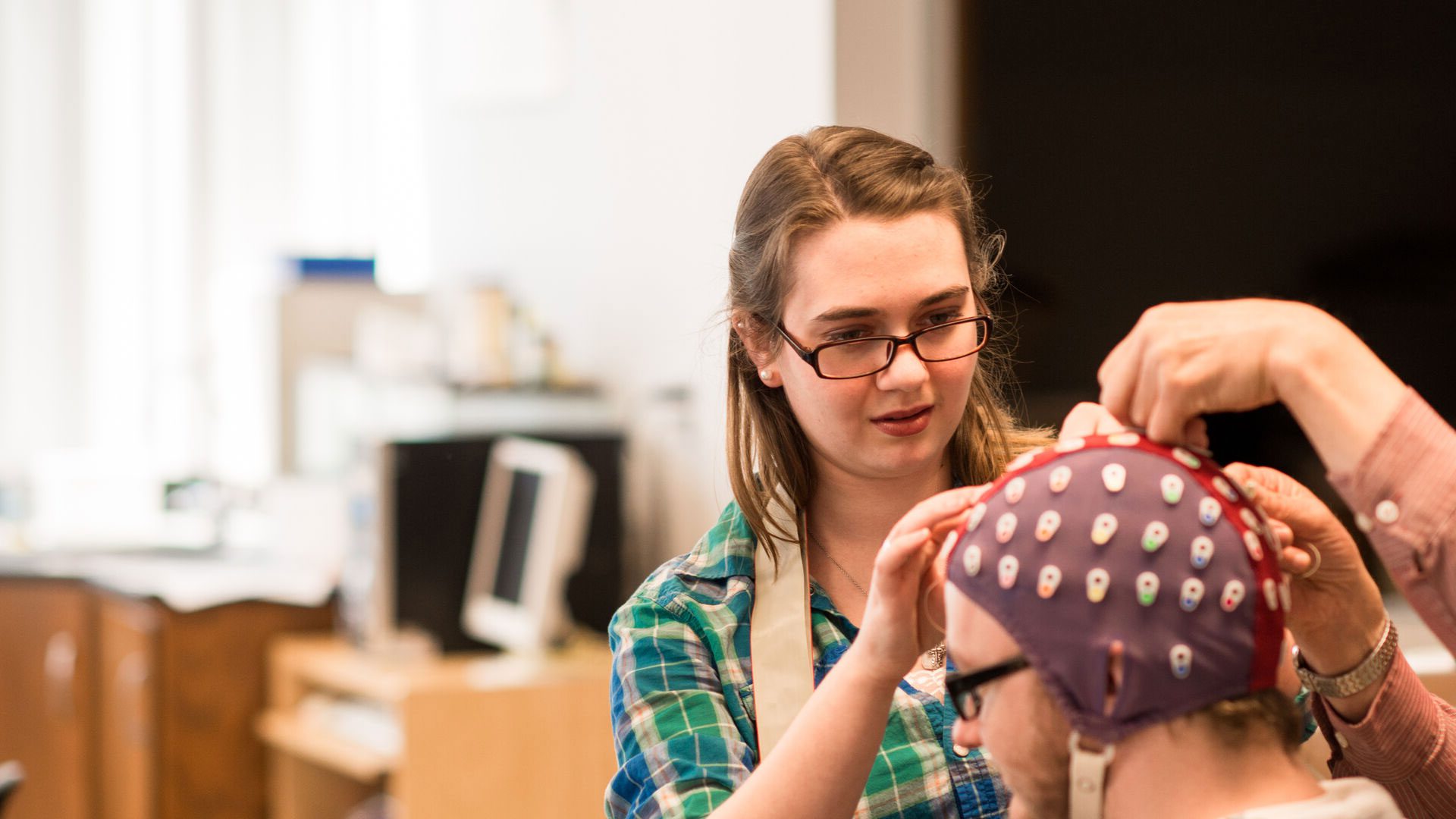 Student attaching a testing device to another student's head.