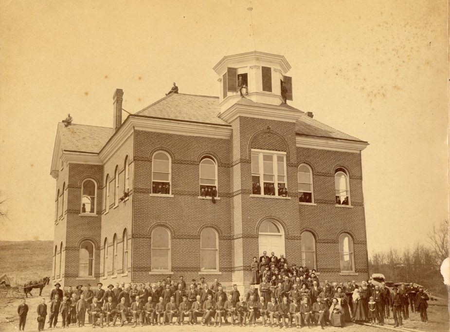 Historic photography of Fancher Hall with people standing out in front.