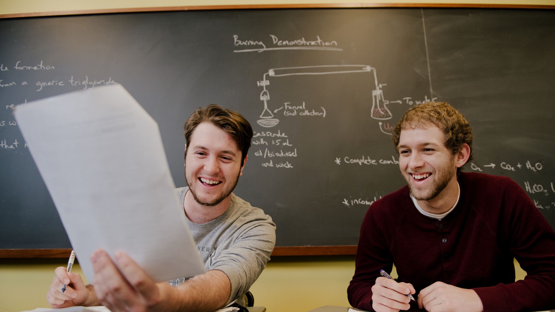 Two Houghton students working on biochemistry problems in a classroom.