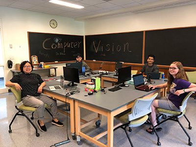 Students and Professor sitting in computer science classroom.