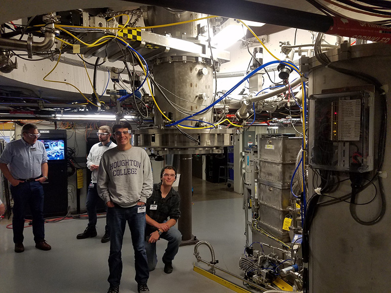 Houghton students standing with LLE staff in the Laboratory for Laser Energetics.