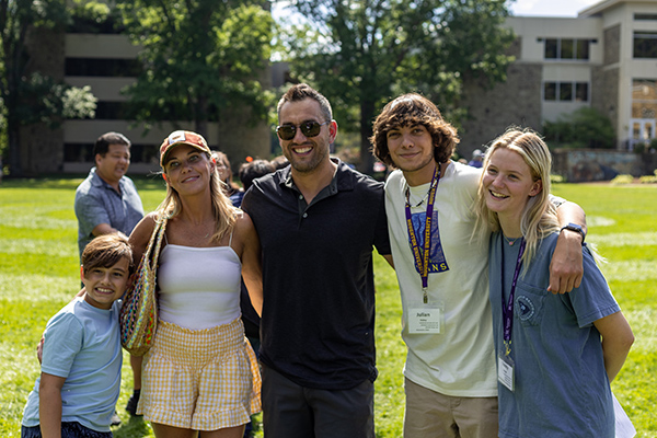 Students standing with their family on Houghton campus lawn.
