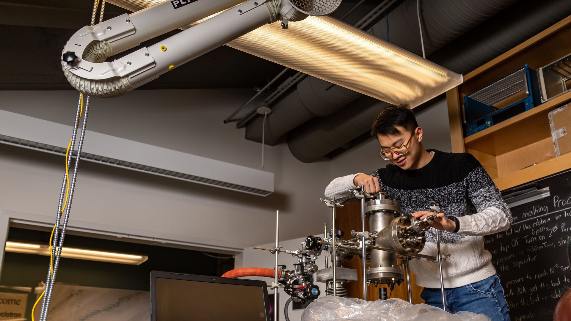 Houghton student working with physics equipment in lab.