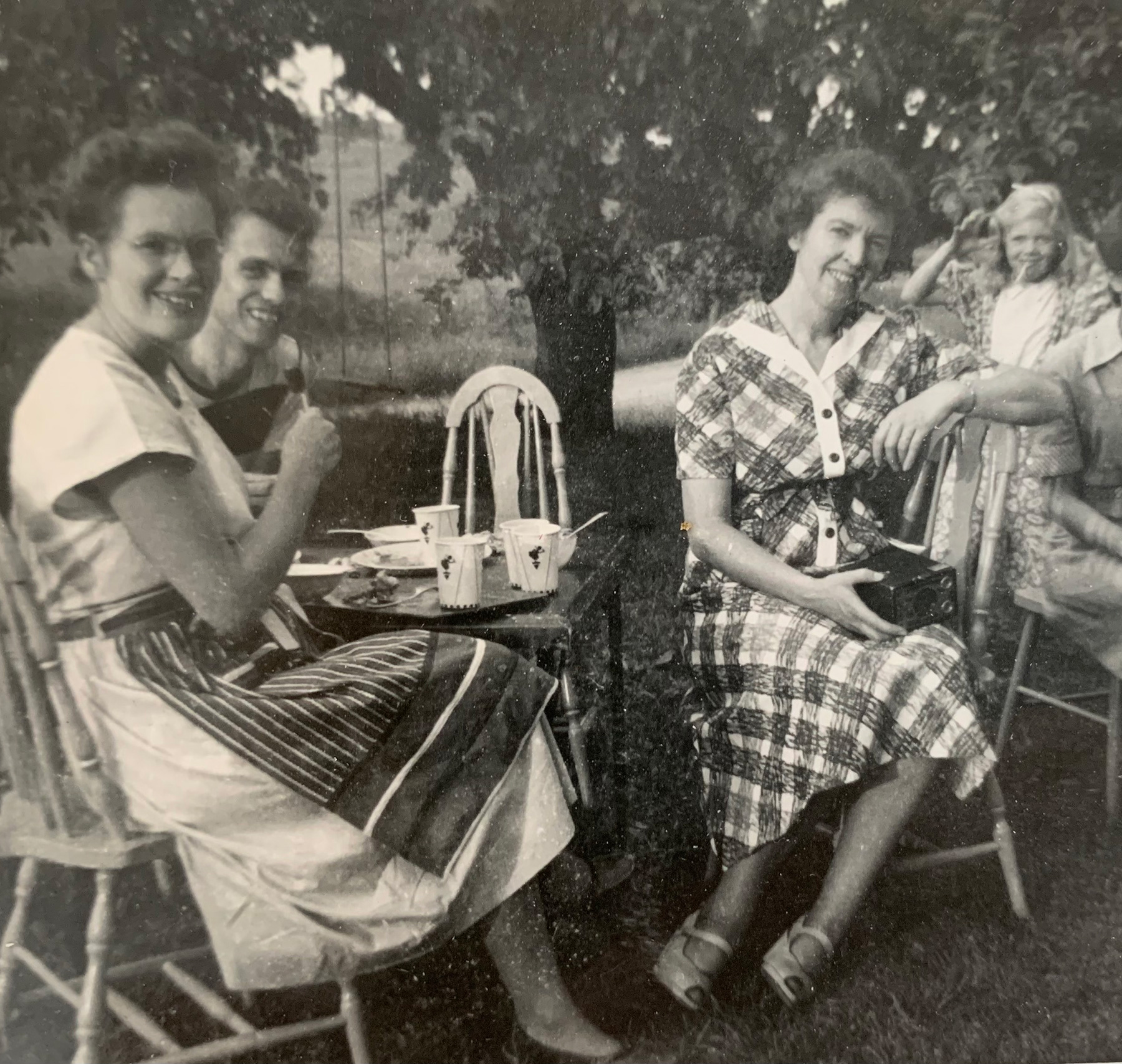 Black and white archive photograph of women sitting at tables outside including Marjorie Ortlip Stockin.