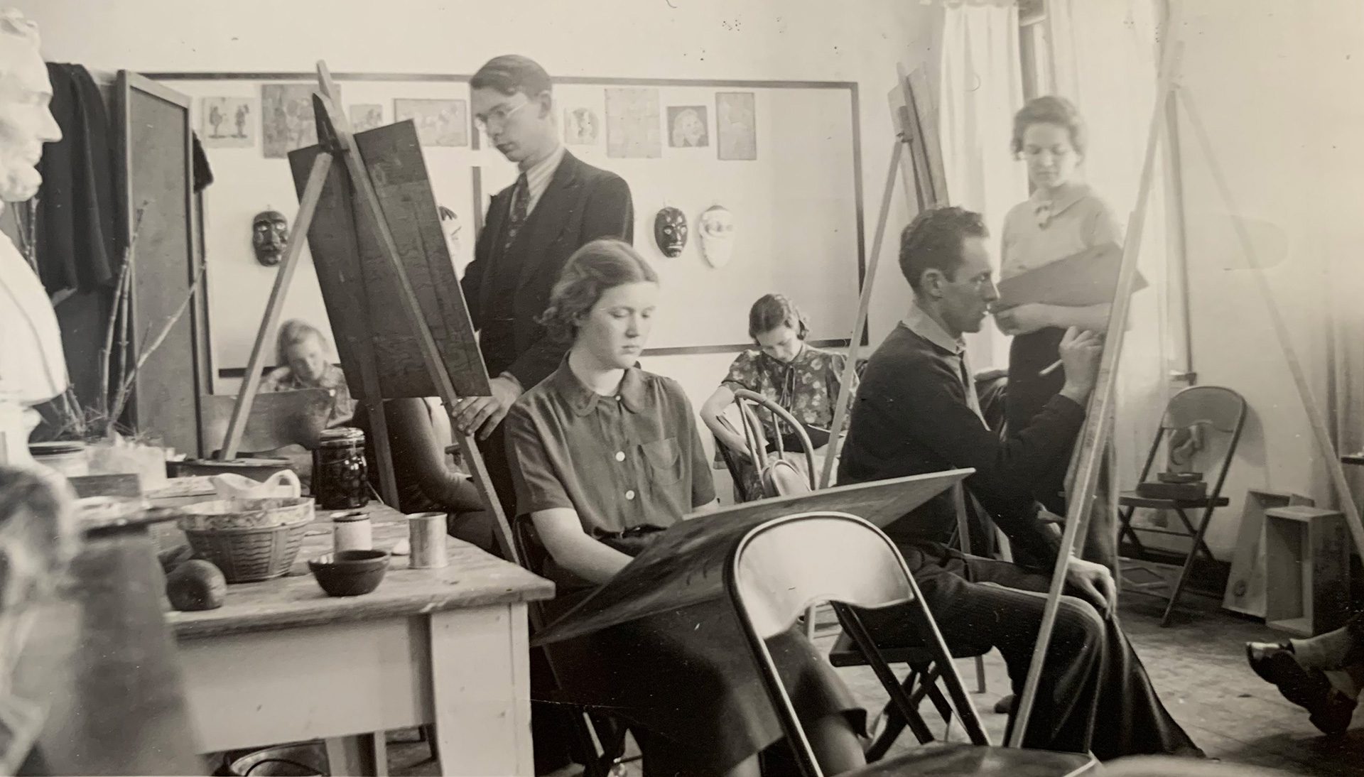 Historic black and white photo of members of the Ortlip family painting.