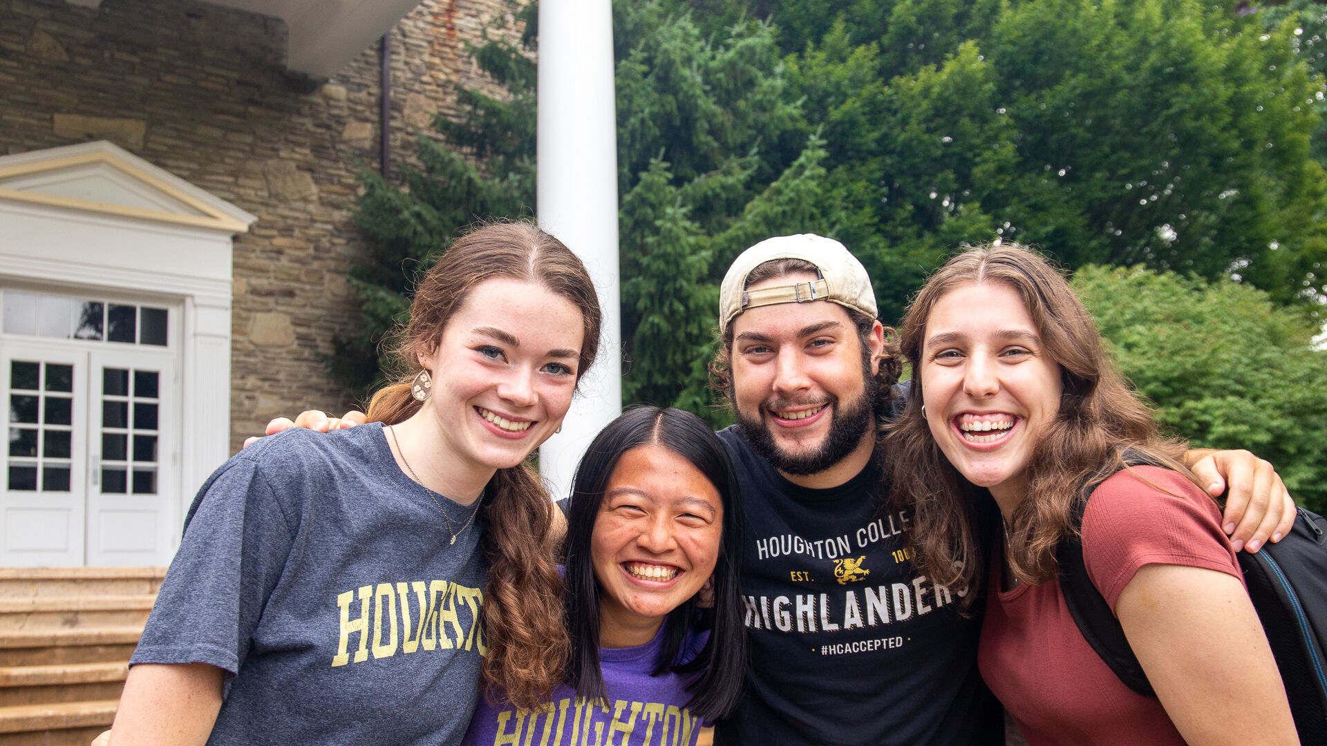 Four Houghton students standing together in front of the Wesley Chapel.