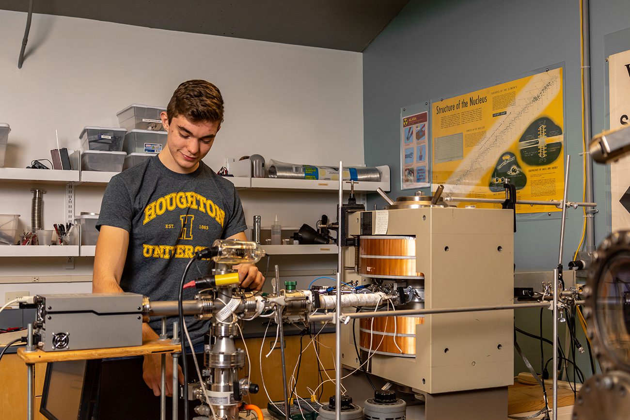 Houghton student working with instruments in physics lab.