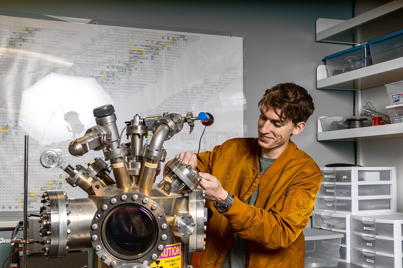 Houghton student working with electrostatic confinement fusion instrument in physics lab.