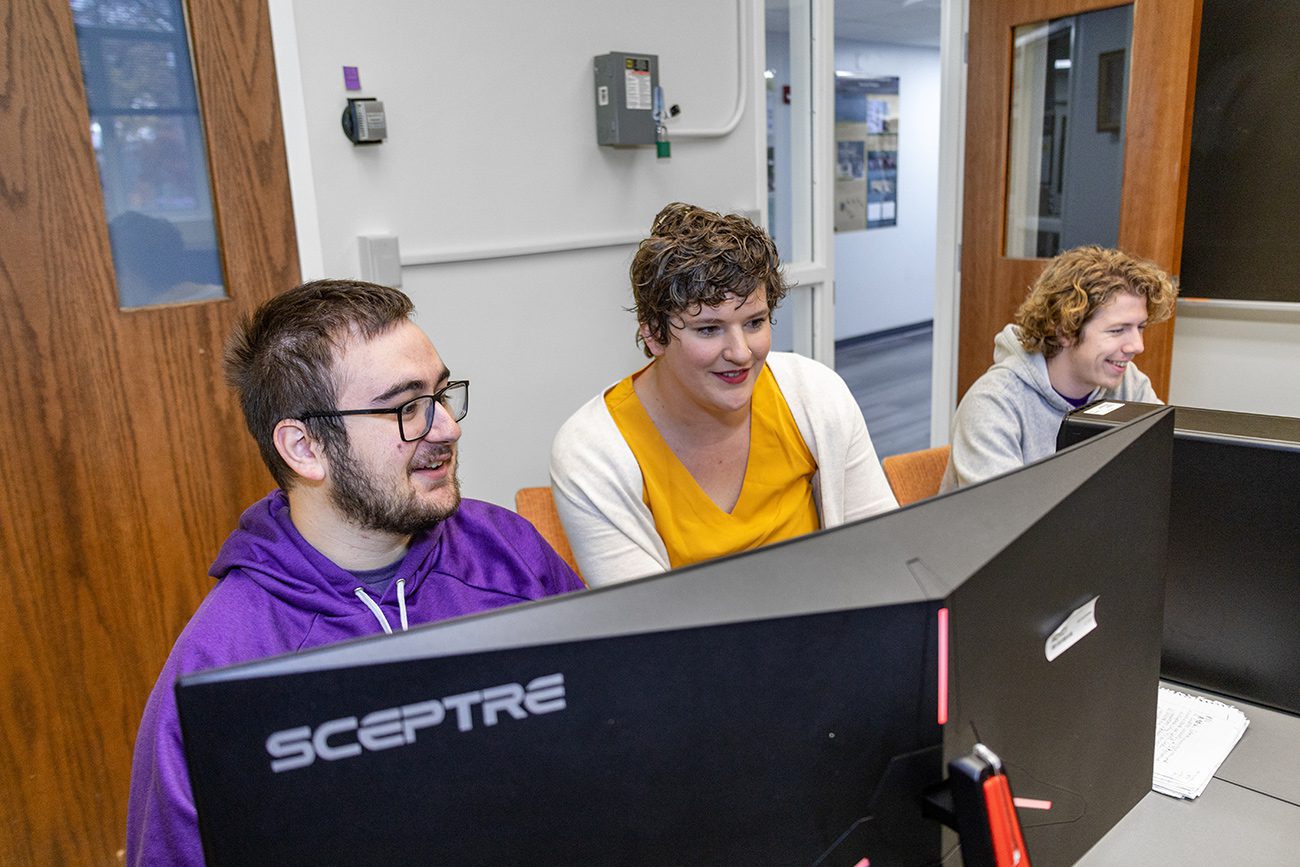 Houghton Professor Koehler working with two physics students at computer.