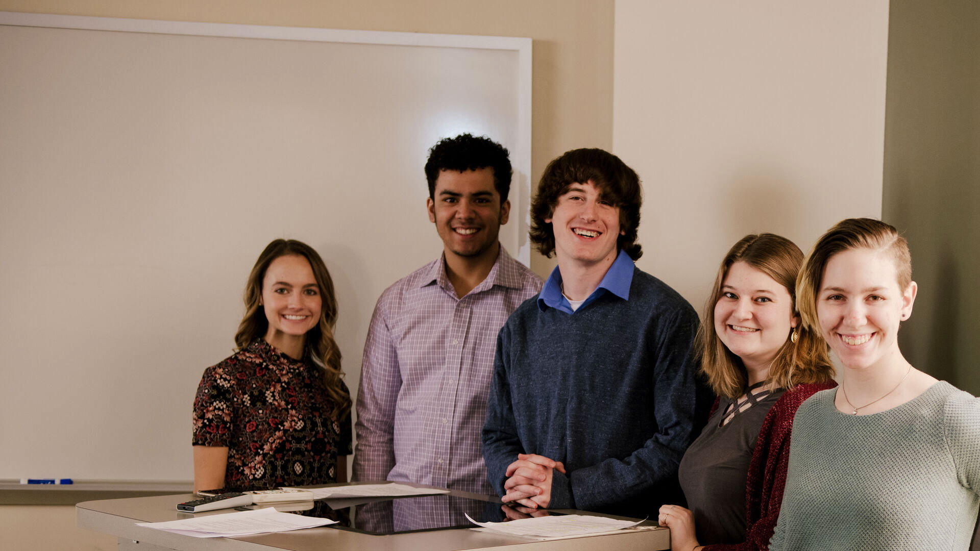 Five Houghton University business students standing and presenting at the front of class.