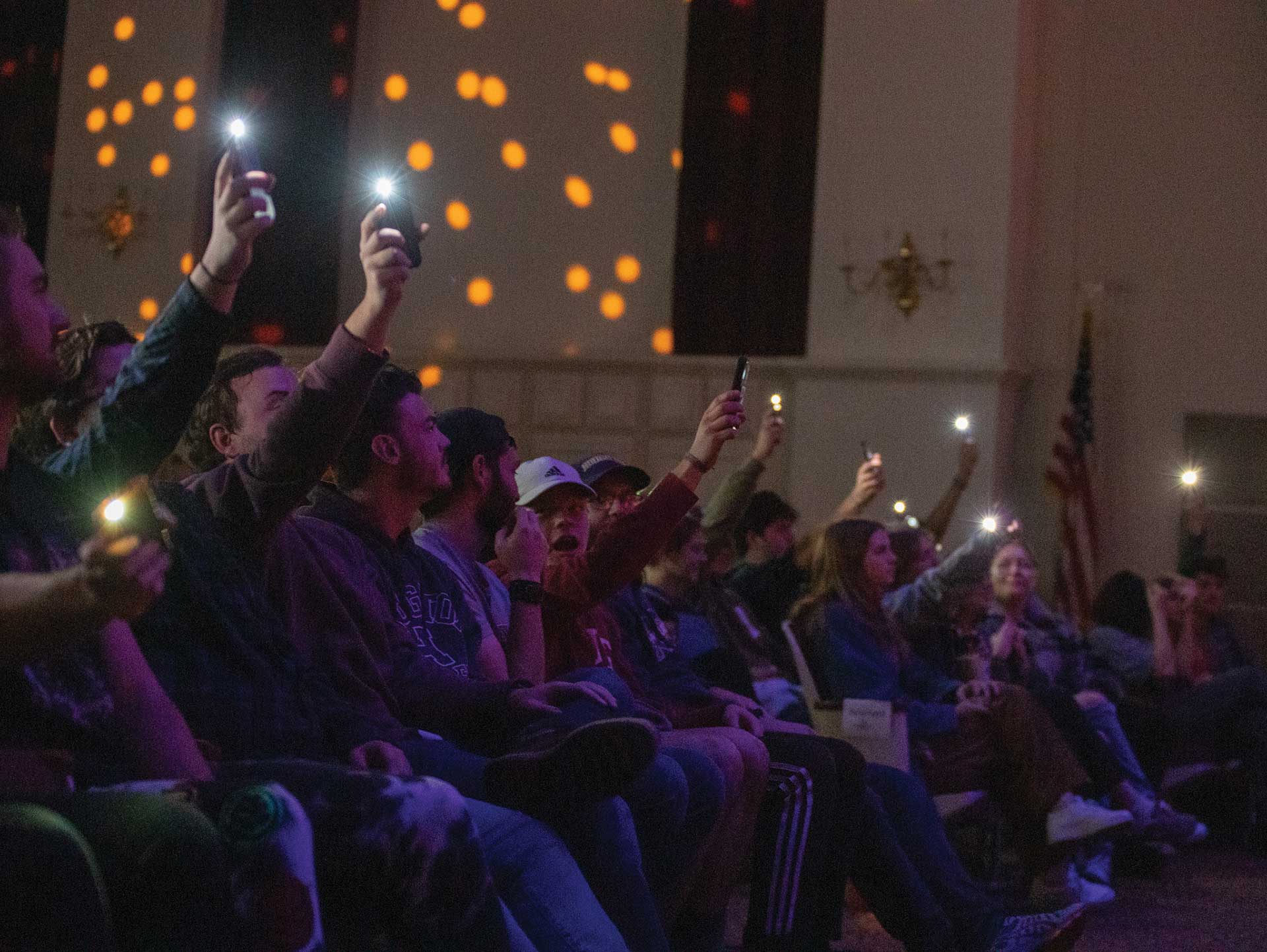 Houghton students raising their phone cameras during performance at homecoming weekend.