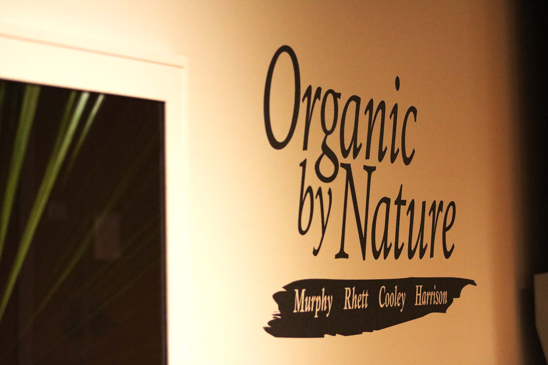 Organic by Nature black letters on gallery wall.