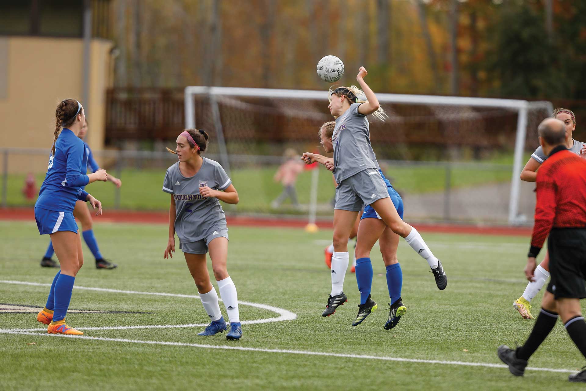 Student heading a soccer ball during a homecoming women's soccer game at Houghton.