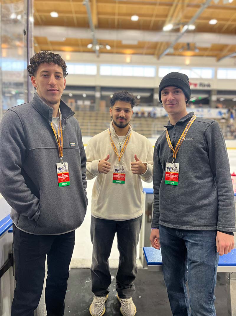 Three Houghton University student volunteers at the New York State Boys Ice Hockey Championships, hosted by the LECOM Harborcenter in Buffalo, NY.
