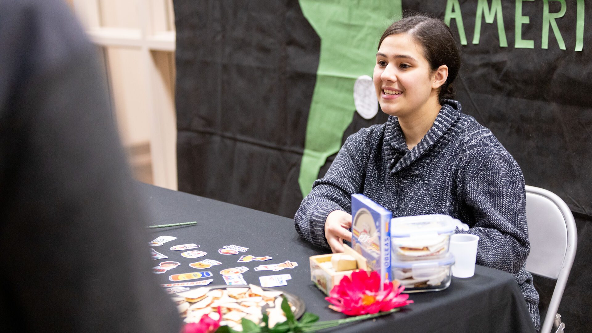 Houghton student sitting at South American table at the multicultural around the world event.