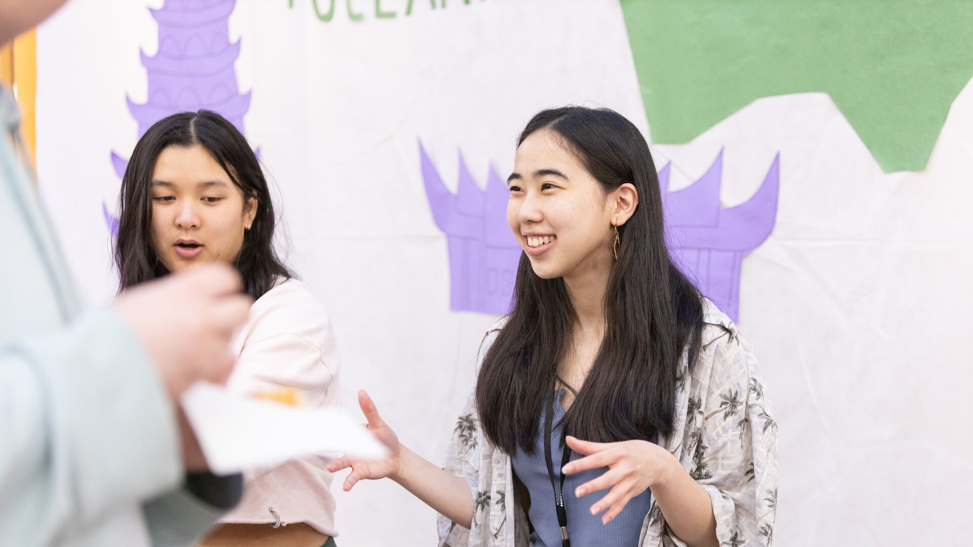 Two Houghton students standing and talking at the multicultural around the world event.