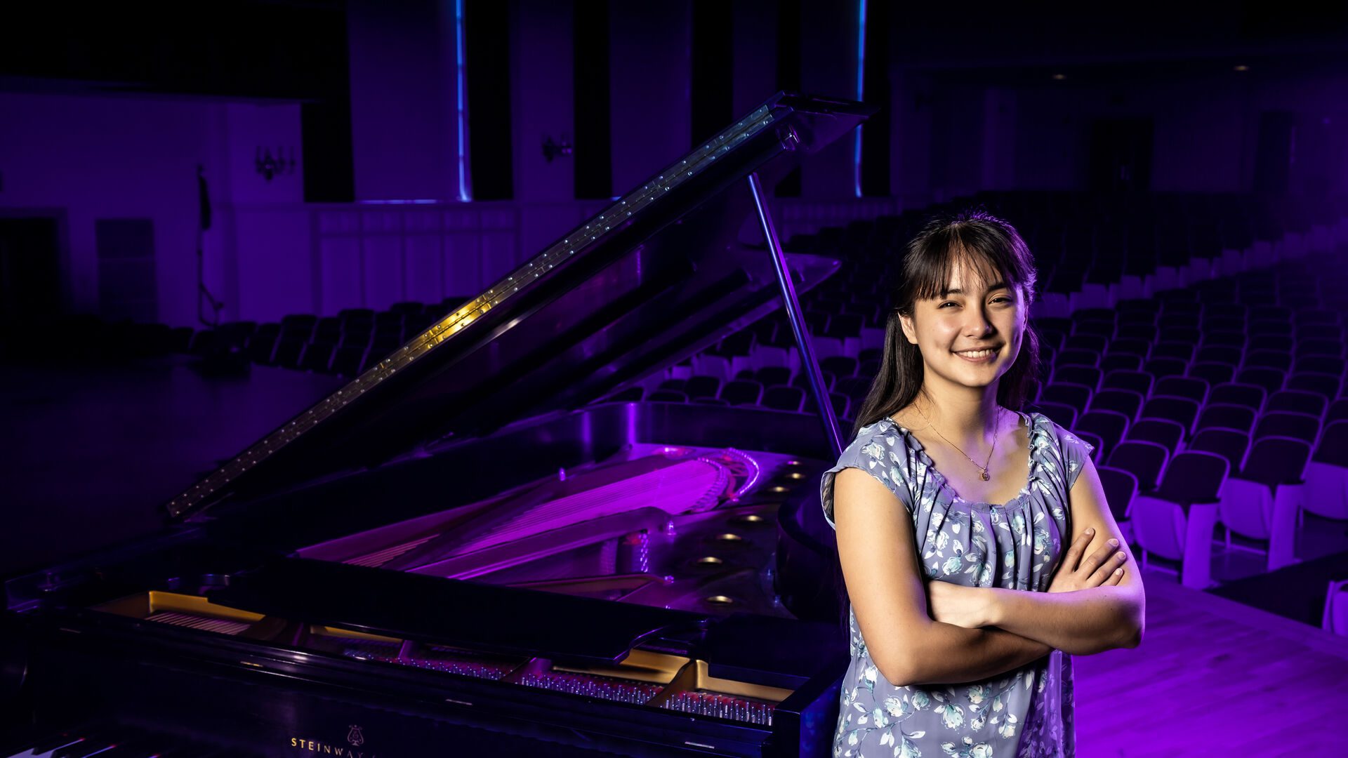 Houghton music student Rachel Huchthausen standing next to grand piano.