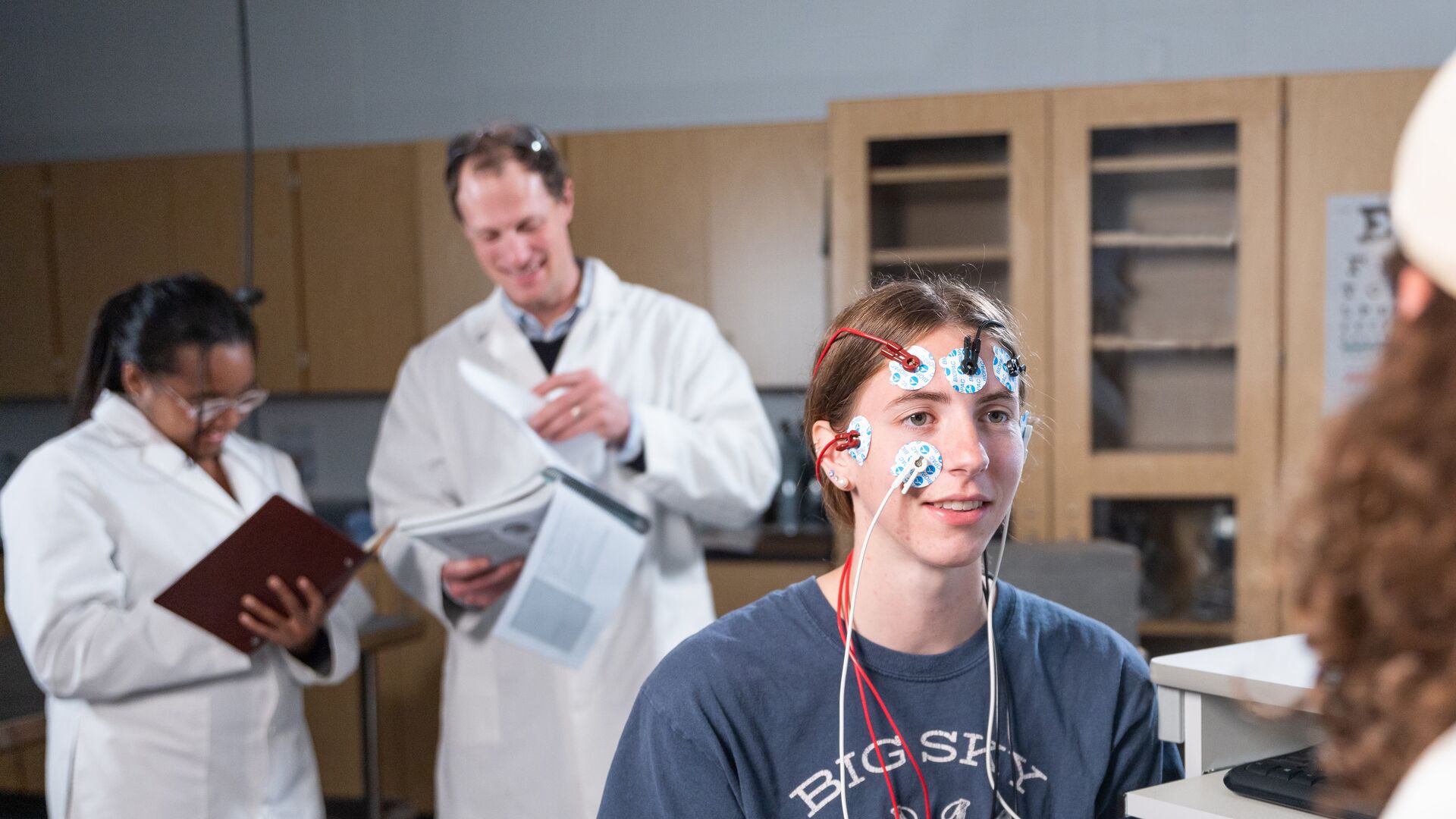 Houghton student wearing biopac sensors in biology lab.