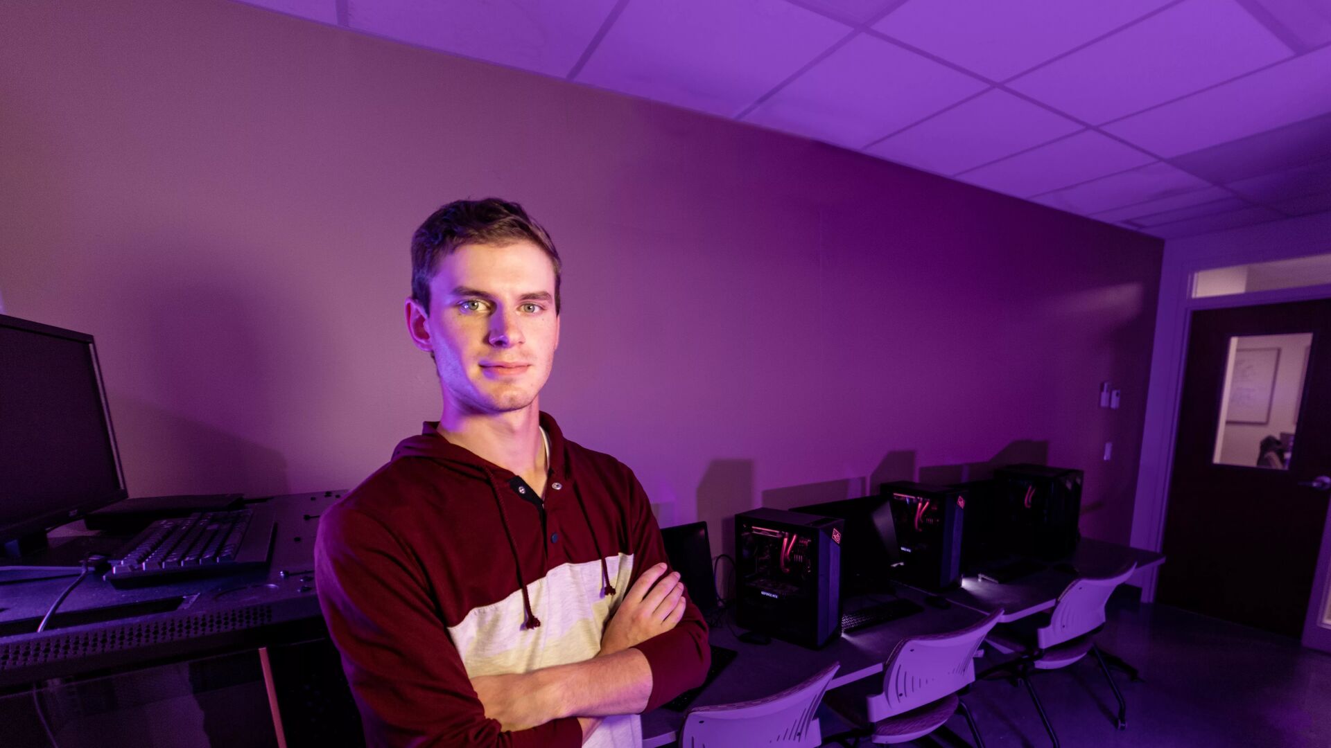 Houghton alum Isaac Cassulis standing in data science lab.