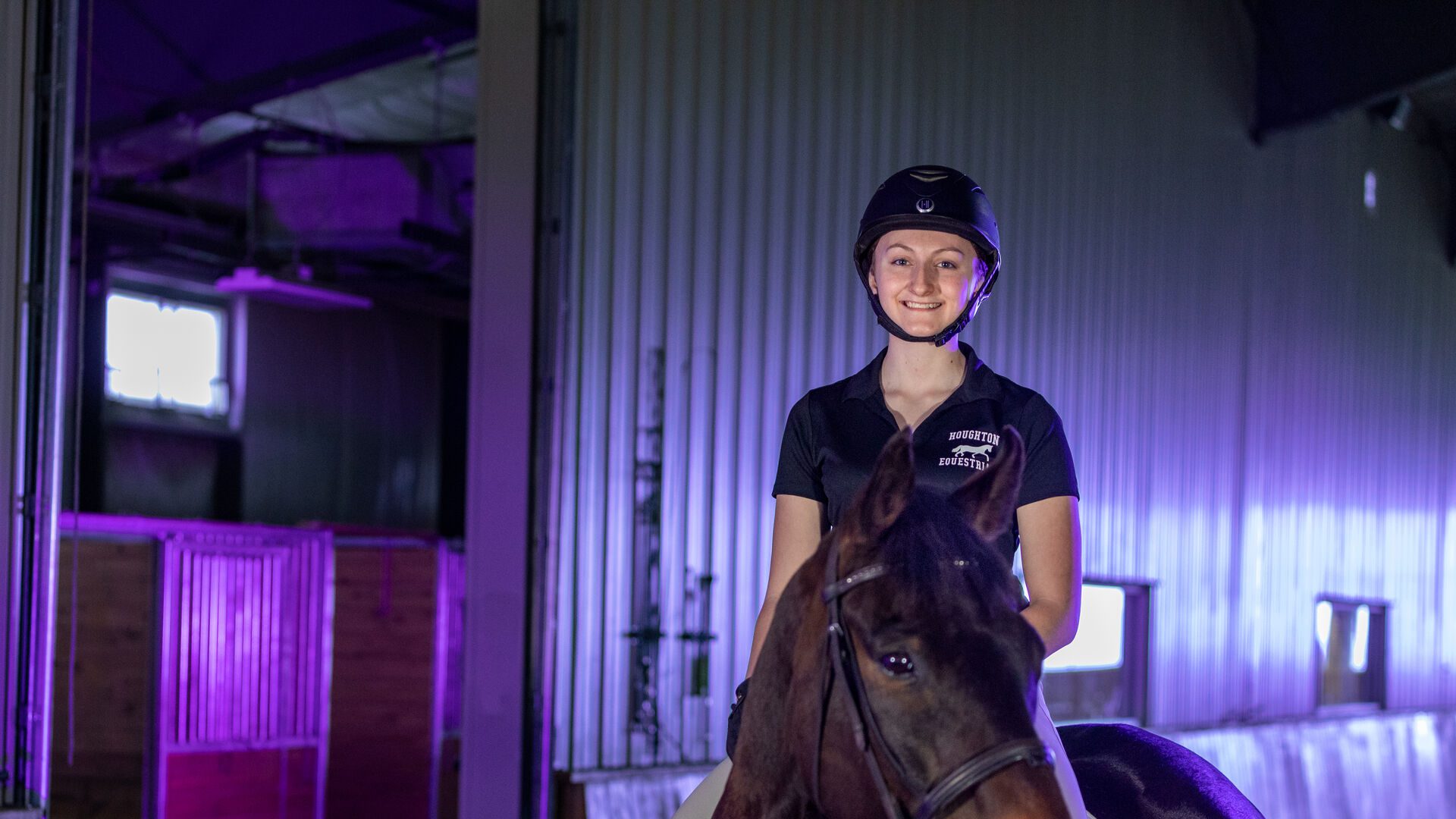 Houghton student Katie sitting on her horse in the Equestrian Center.