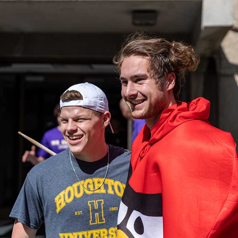 Two Houghton students, one with Houghton tshirt and the other in an angry bird costume, helping during move-in.