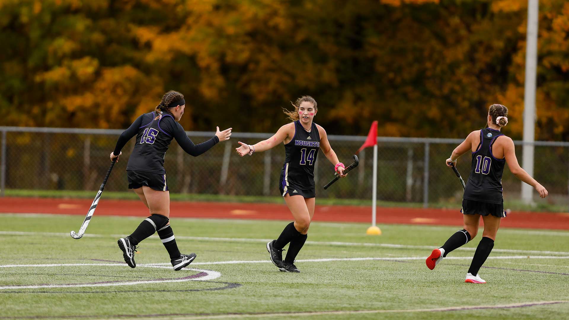 Houghton women's field hockey team playing during game.