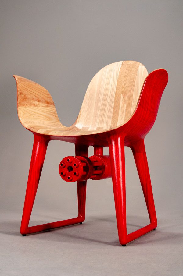 Mid-century modern chair with bright red undersides and light maple wood top, embellished underneath piece of a cold-war era American plane engine