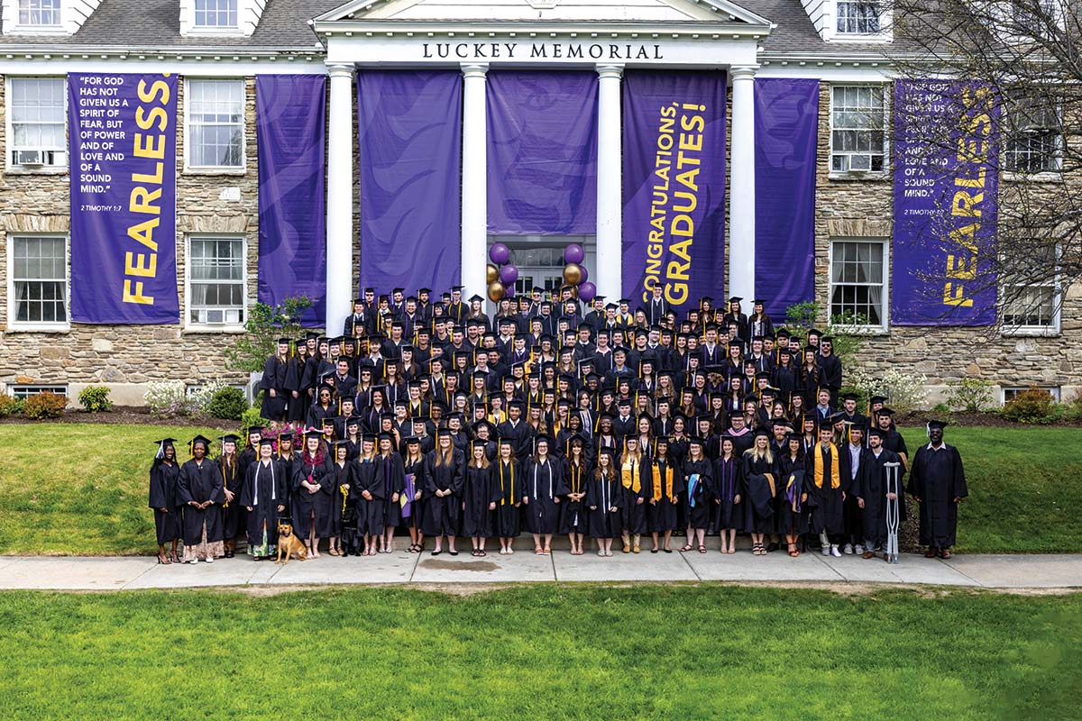 Houghton's 2023 graduating class standing in front of the Wesley Chapel.