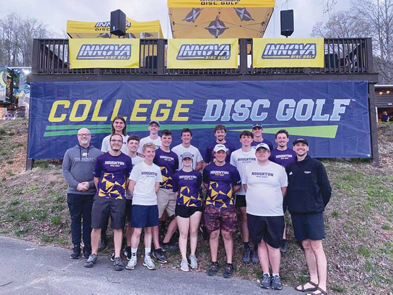 Houghton's Disc Golf Team standing in front of championship banner.