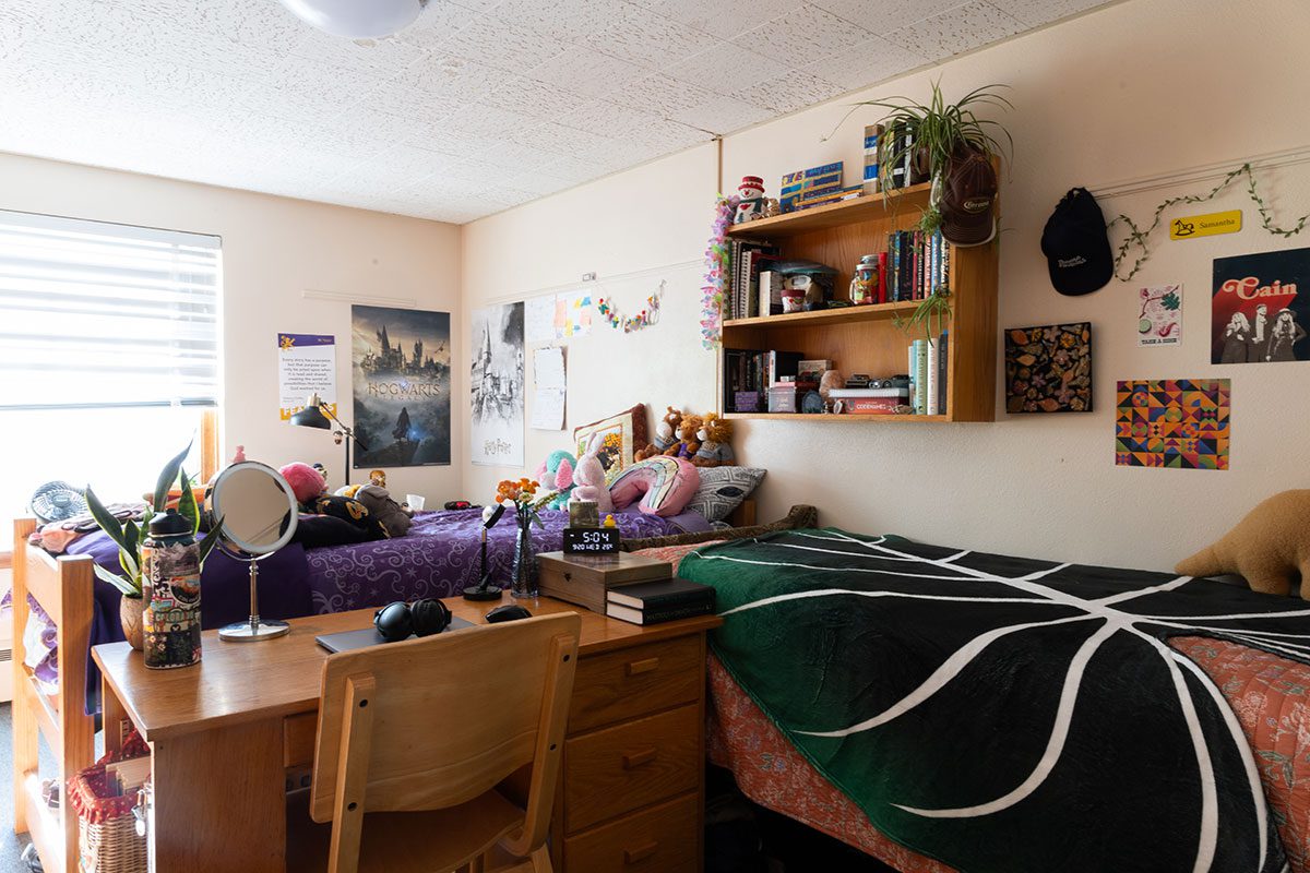 Interior view of Gillette Hall at Houghton University. Beds, desk, chair and shelf.
