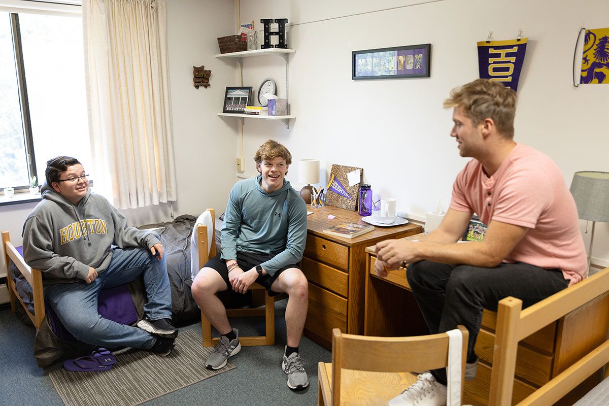 Three students sitting together in a room in Lambein Hall at Houghton University.