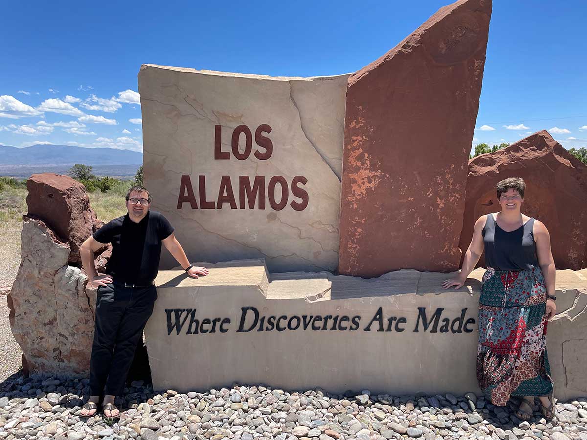 Houghton physics professor Katrina Koehler and Houghton student by Los Alamos outdoor sign.