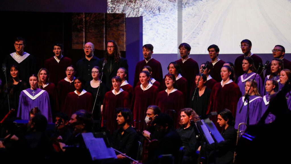 Houghton University choir singing during Christmas prism on stage.