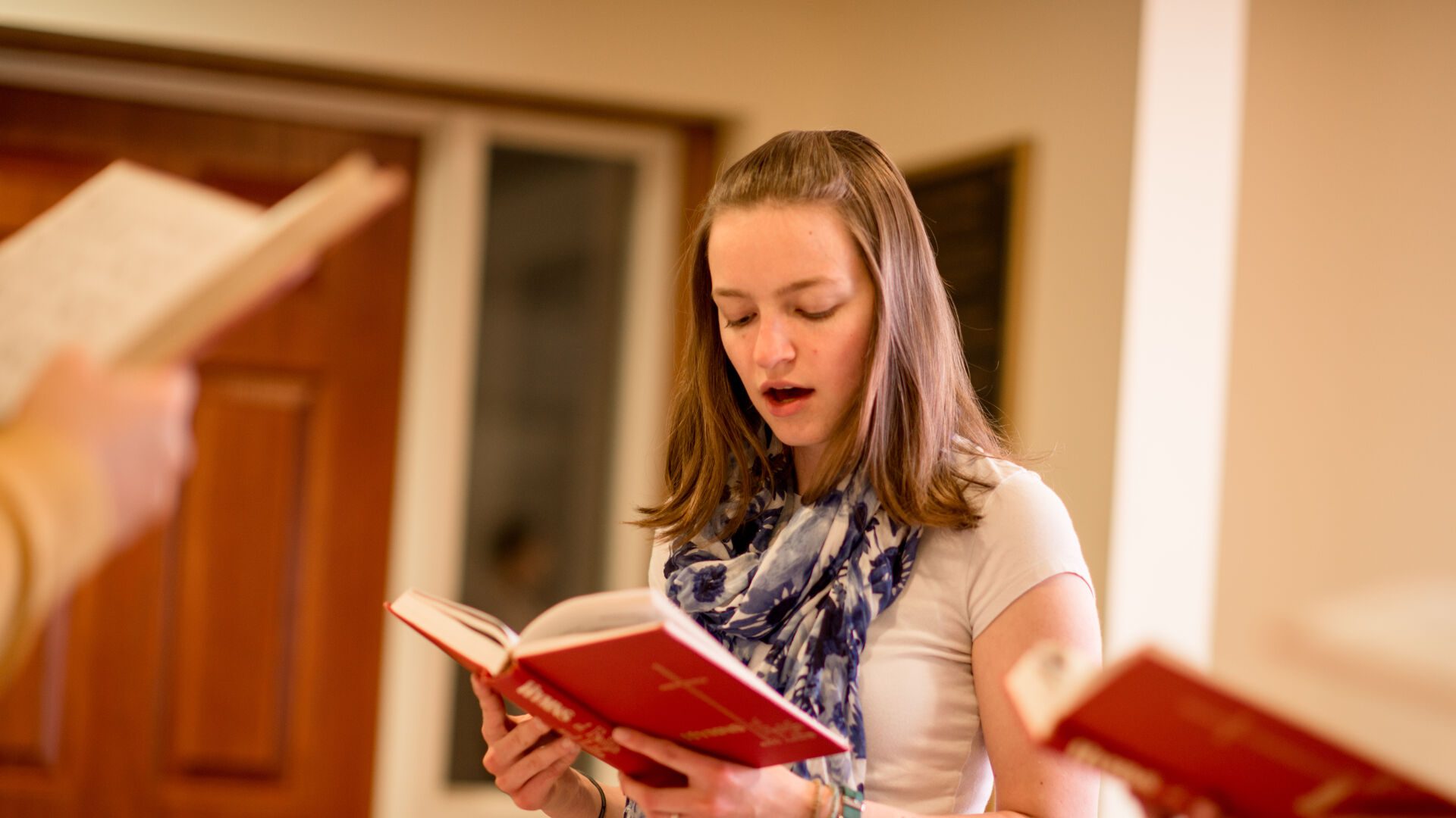 Houghton student singing out of hymnal.