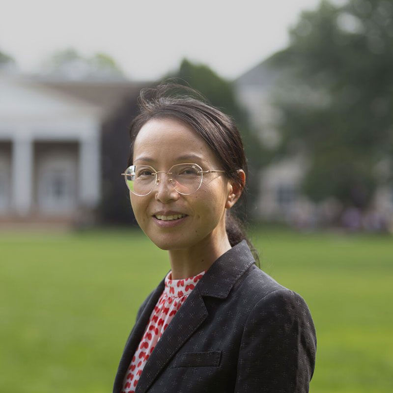 Houghton professor Min Wang with dark blazer and patterned shirt.