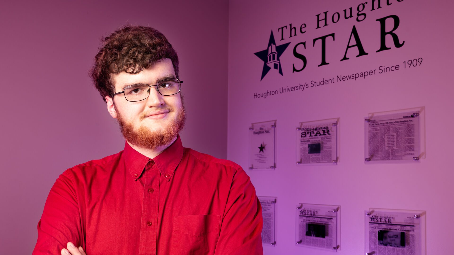 Houghton student Christian Welker standing by The Houghton STAR entry wall.