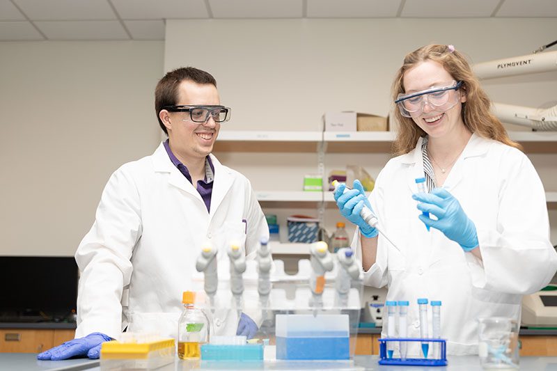 Houghton professor Daniel Hammers working in lab with Emily Wahlenmayer.